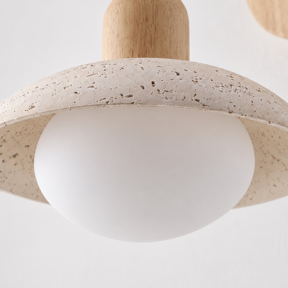 Travertine disc shade covering a frosted white globe