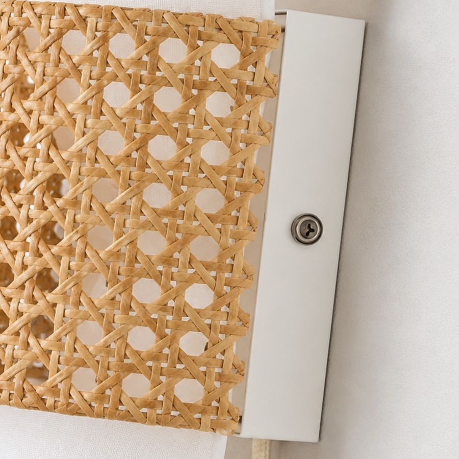Rattan edge against a white wall plate with a visible mounting screw