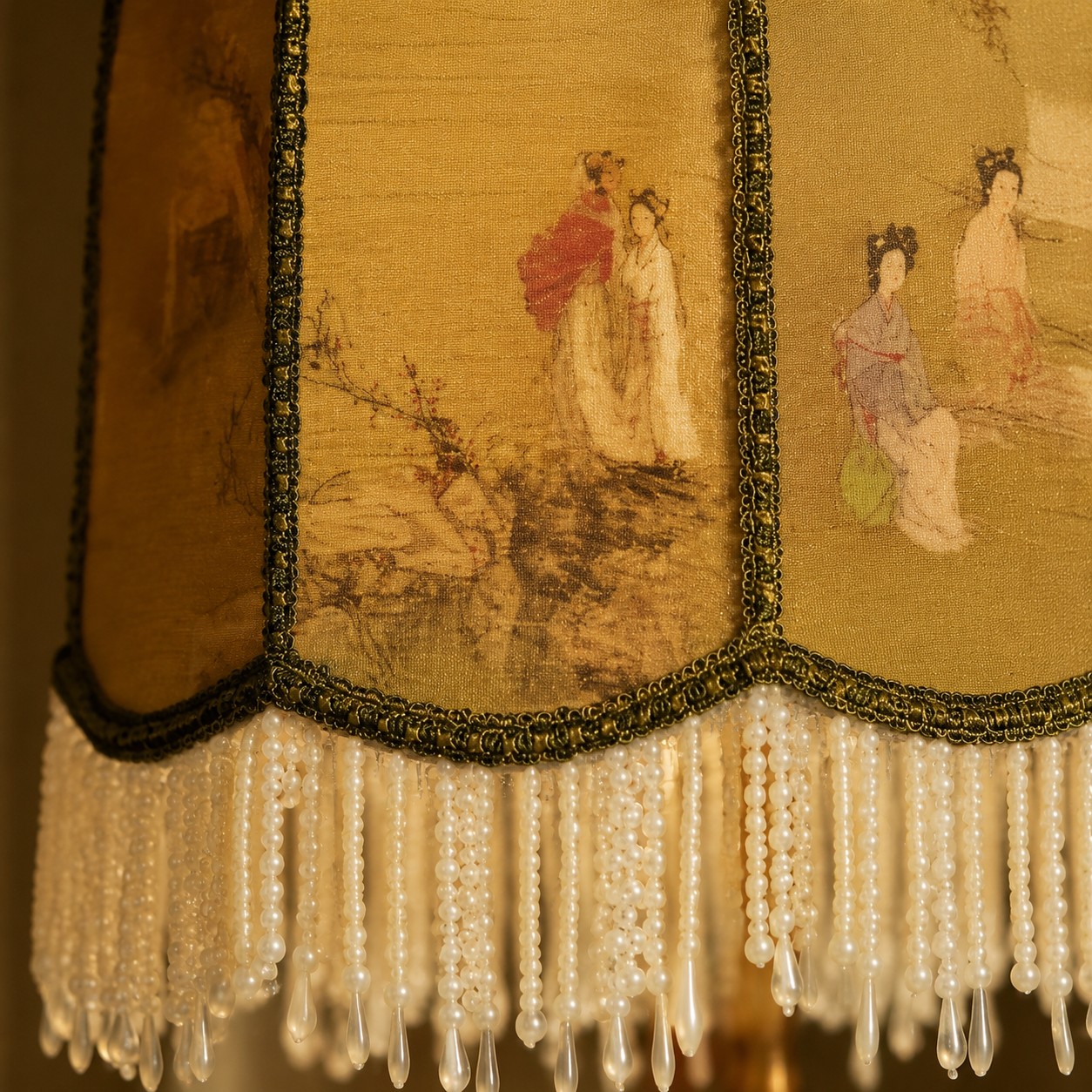 Close-up of beaded fringe and brass lamp fitting
