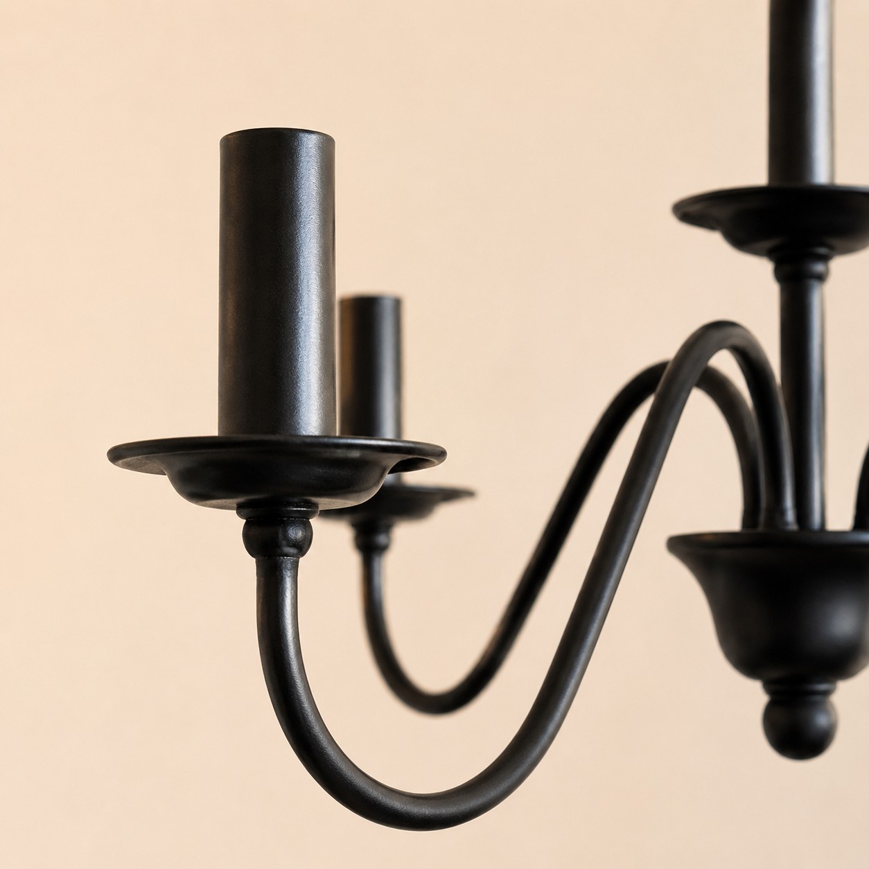 Close view of the matte black candle holder and curved iron arm