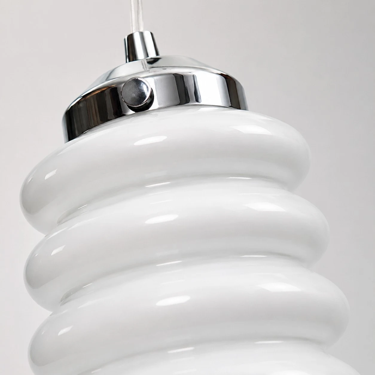 Close view of chrome cap and white ribbed glass shade