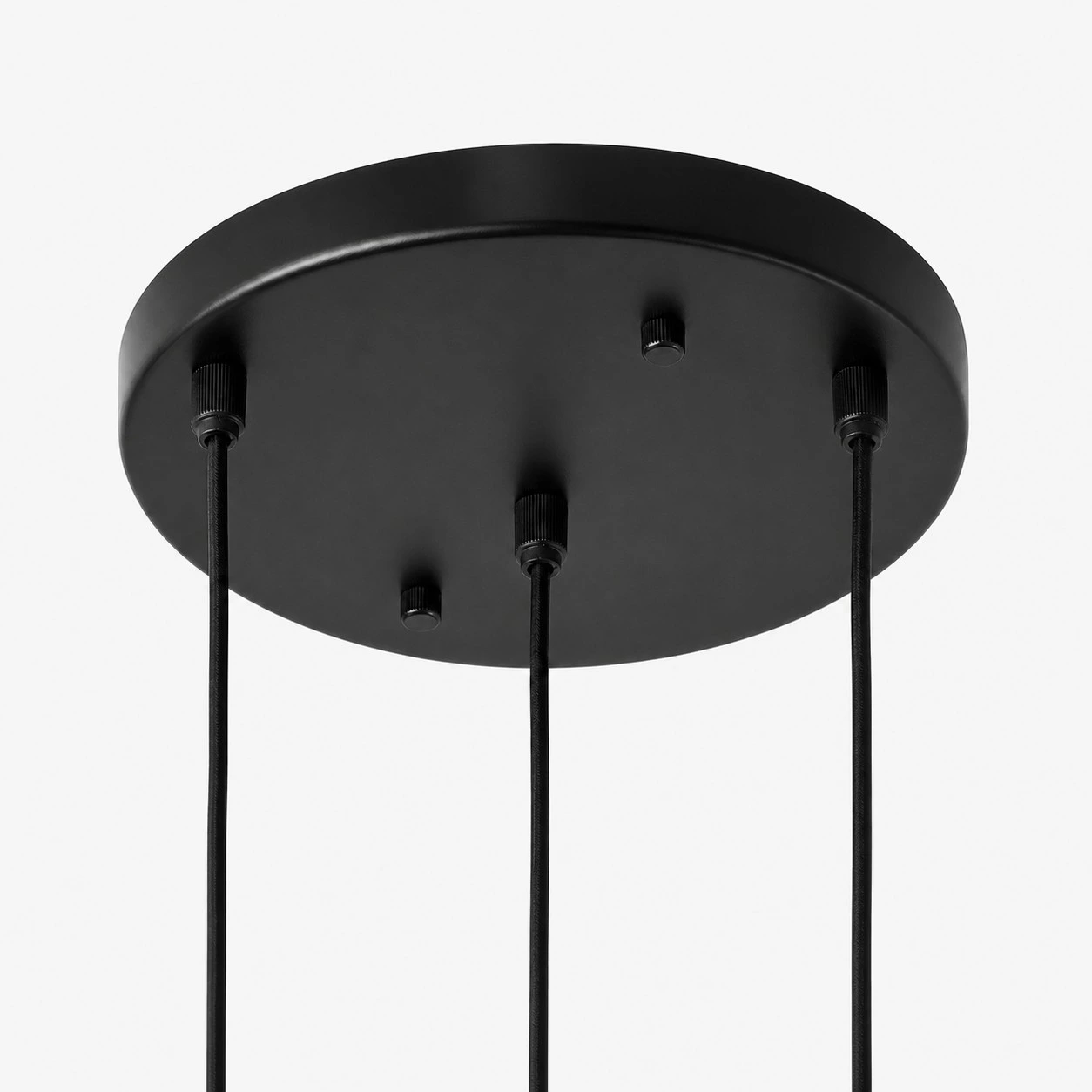 Round black ceiling canopy detail for the staggered three-light pendant