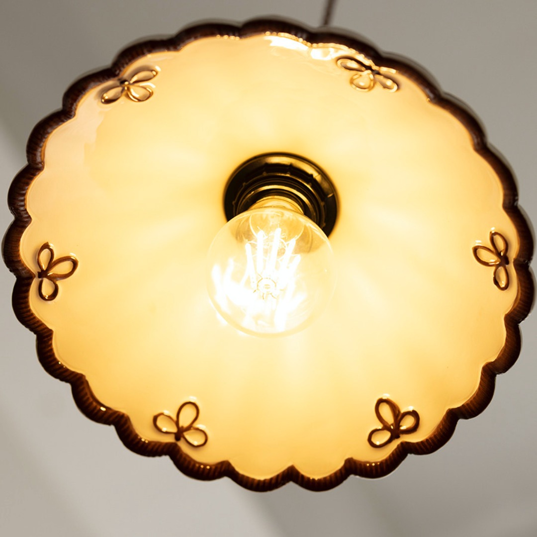 Lit underside detail of scalloped ceramic pendant shade