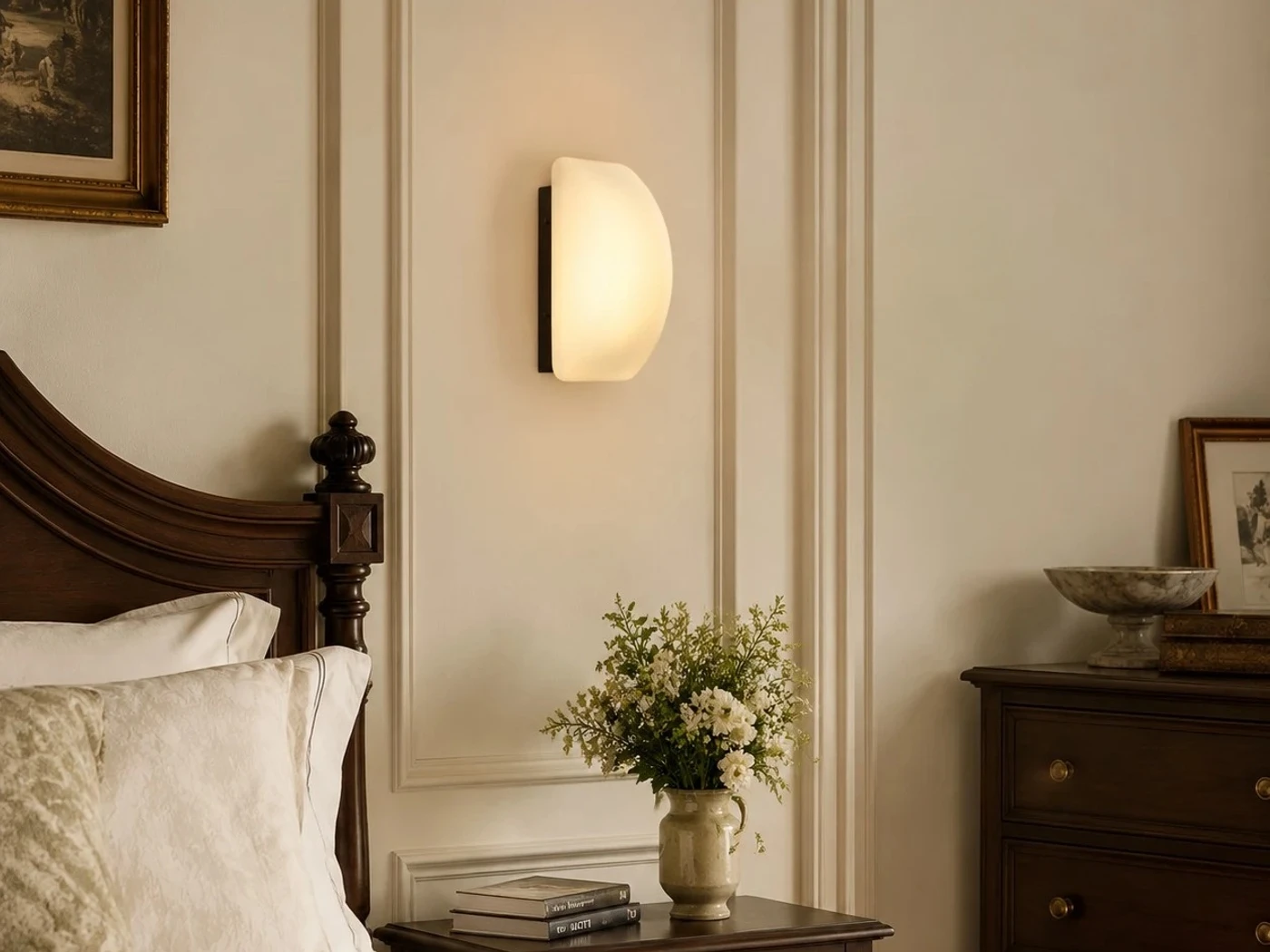 French glass wall sconce beside a classic bed