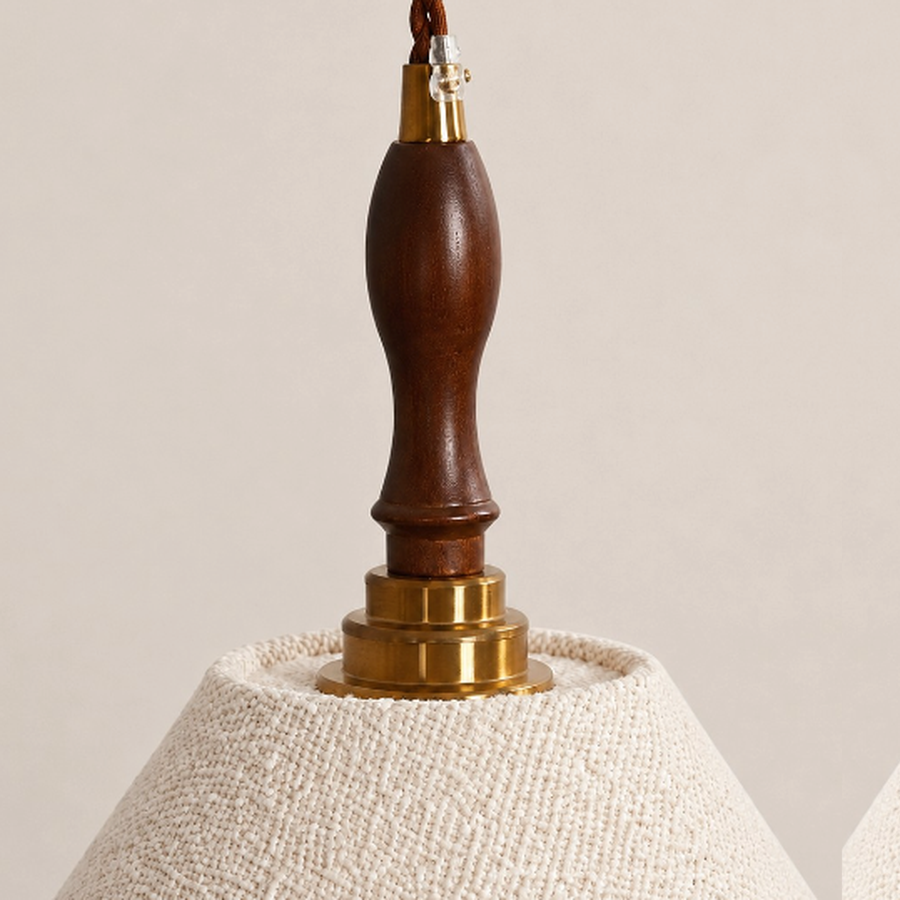 Close view of the dark wood and antique brass pendant suspension detail