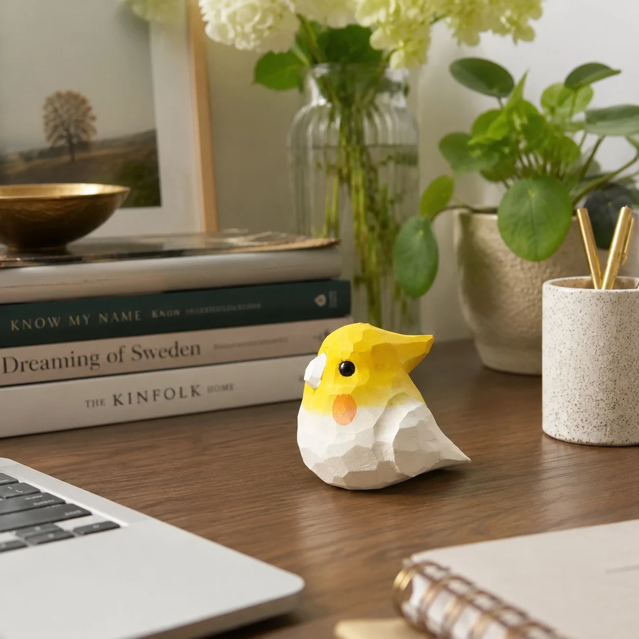 Cute wooden bird ornament styled on a desktop