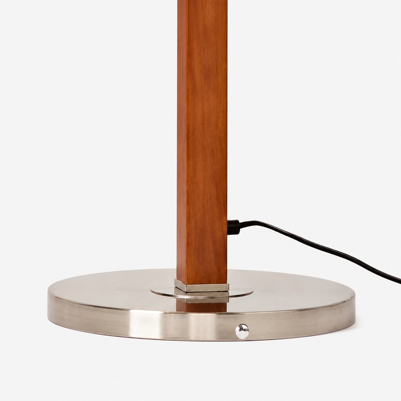 Round metal base and wood-tone floor lamp pole detail
