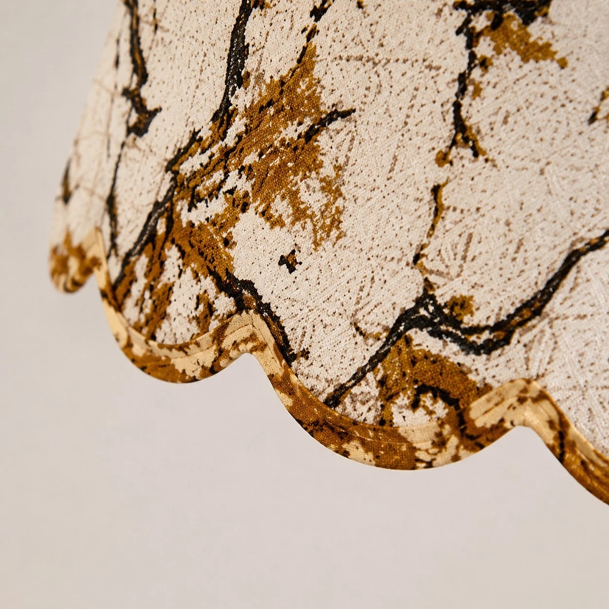 Close view of the raised floral fabric and scalloped edge.