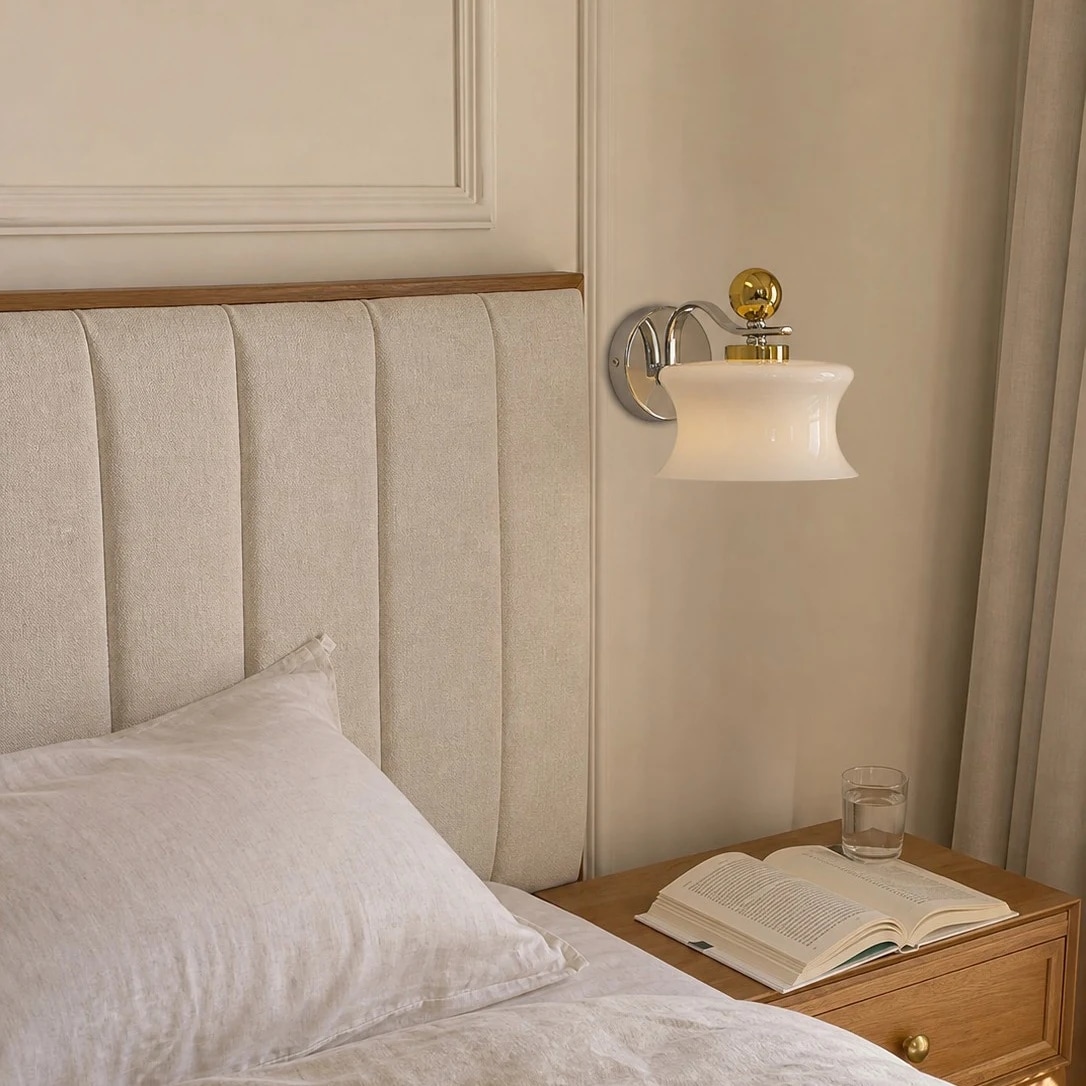 Cream glass wall lamp installed beside a bed