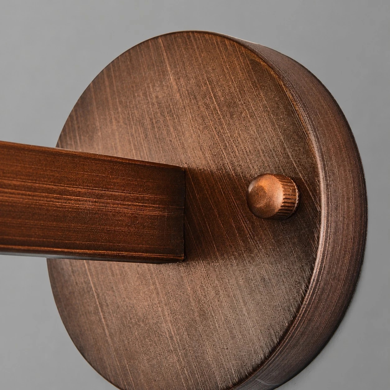Round aged bronze backplate and horizontal arm detail