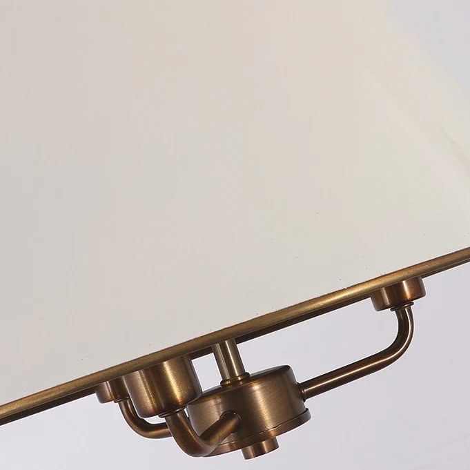 Witte lampenkaprand met messing details.