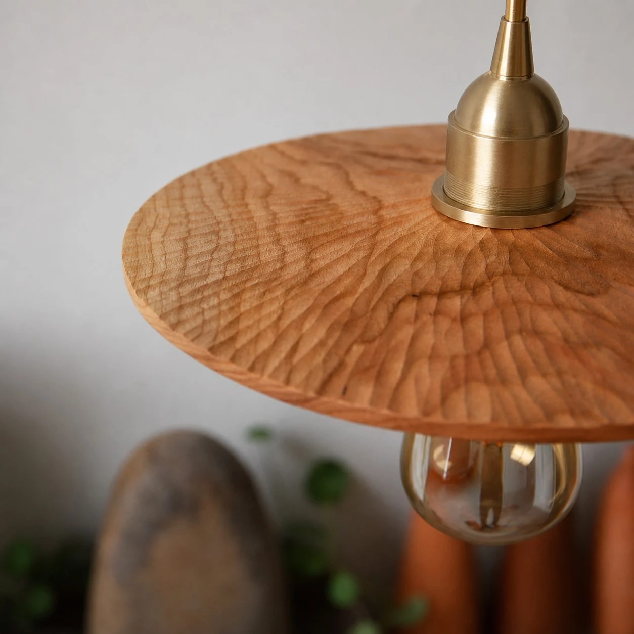 Close detail of carved cherry wood texture and brass lamp holder