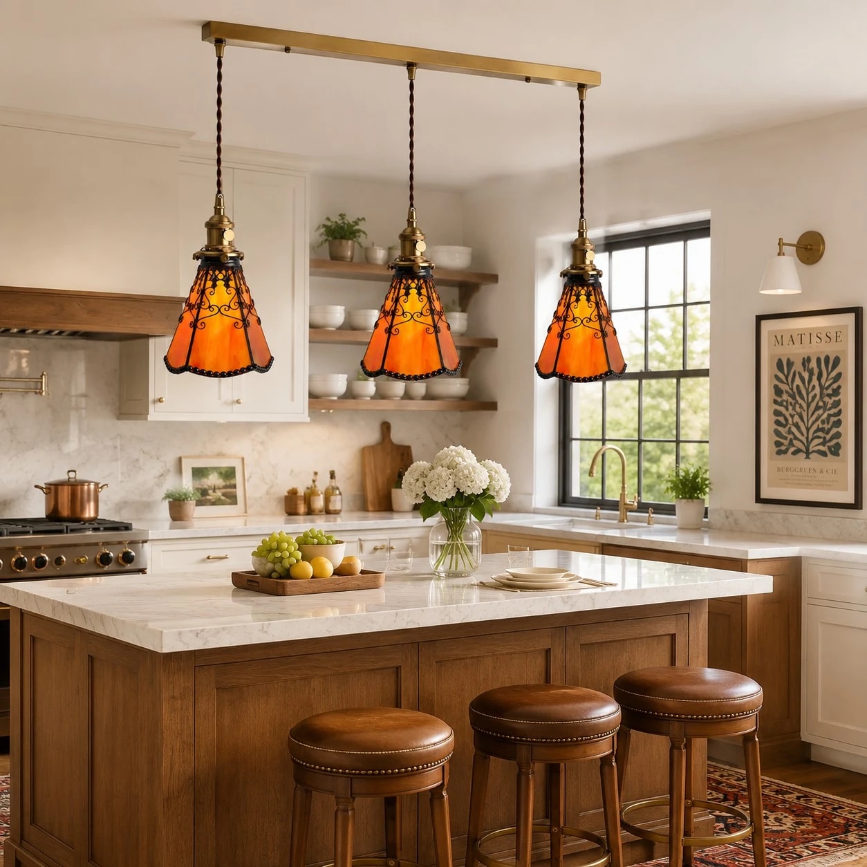 Three orange stained glass pendants over a bright kitchen island