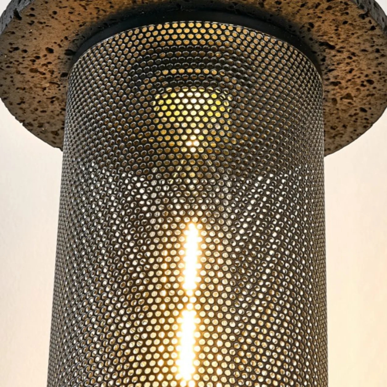 Detalle en primer plano de la pantalla colgante tejida perforada iluminada.