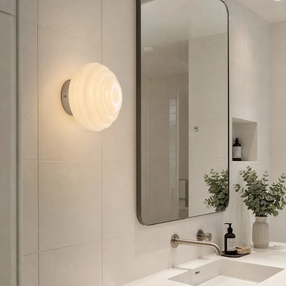 Applique murale en verre côtelé crème près d'un meuble-lavabo de salle de bain