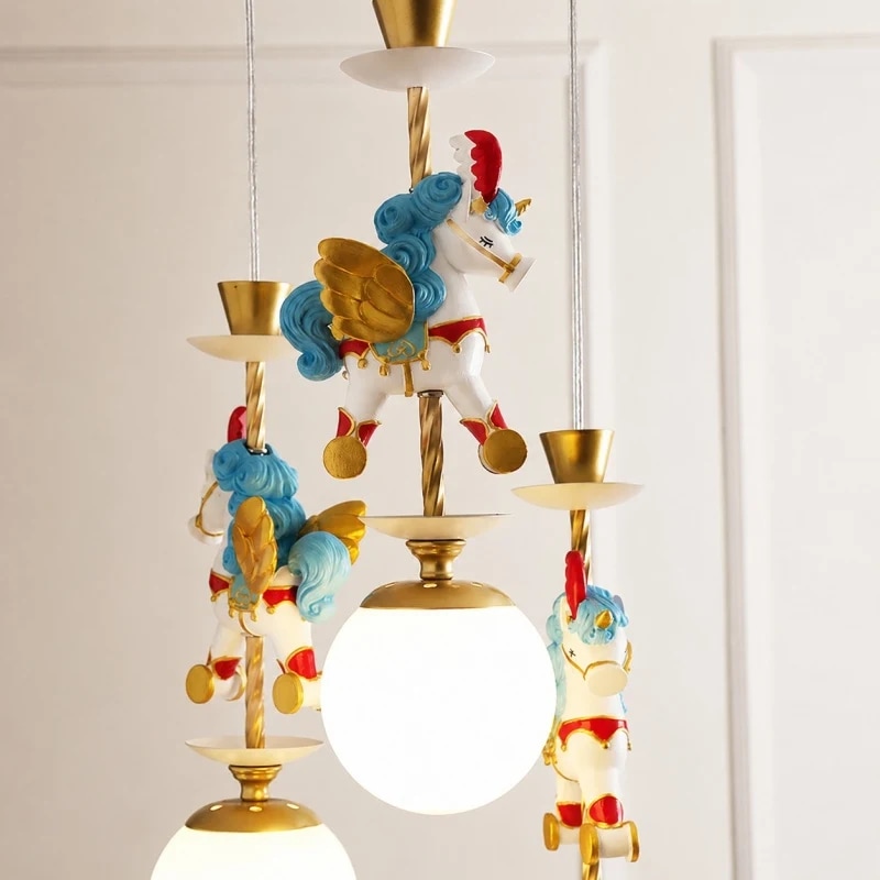Ornamento unicorno blu accanto a un paralume a globo illuminato