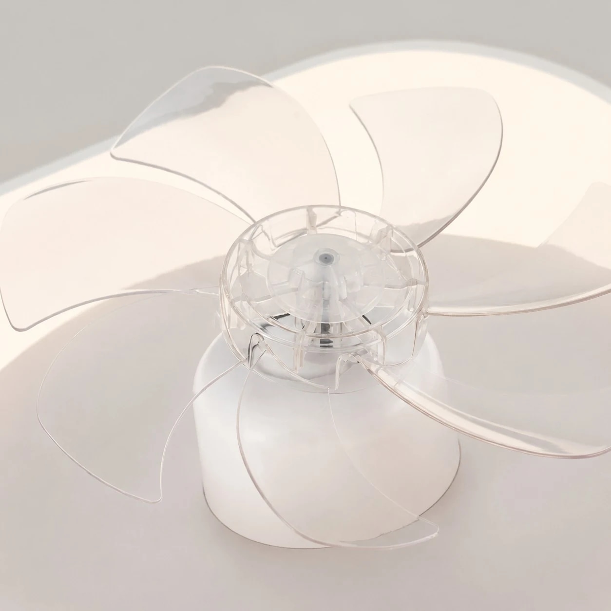 Detalle de aspas de ventilador transparentes en la luz del ventilador de techo