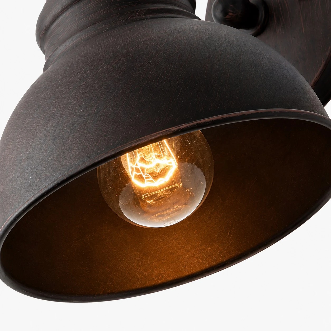 Close view of the rust bronze shade and warm bulb opening