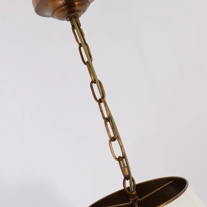 Details van messing ketting en plafondkap op de hanglamp