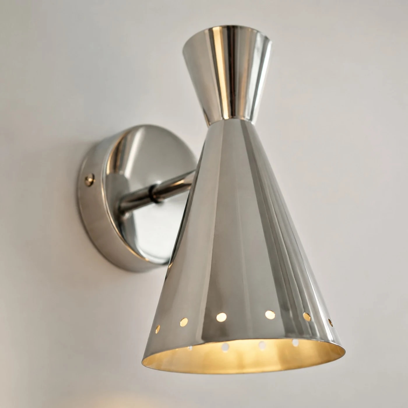 Close detail of polished cone shade and round wall mount
