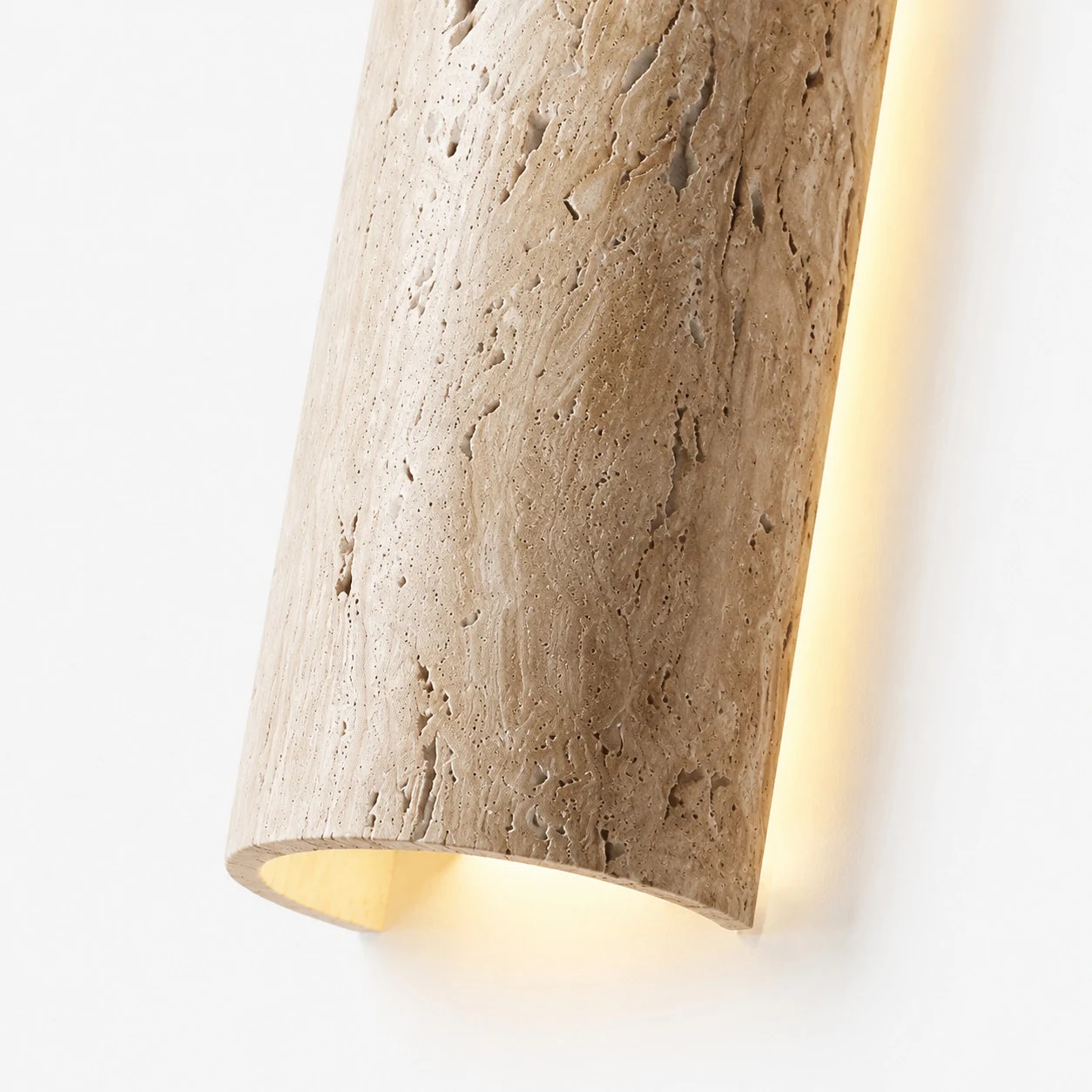 Vista aproximada de um aplique de parede linear LED em travertino com iluminação de borda quente.