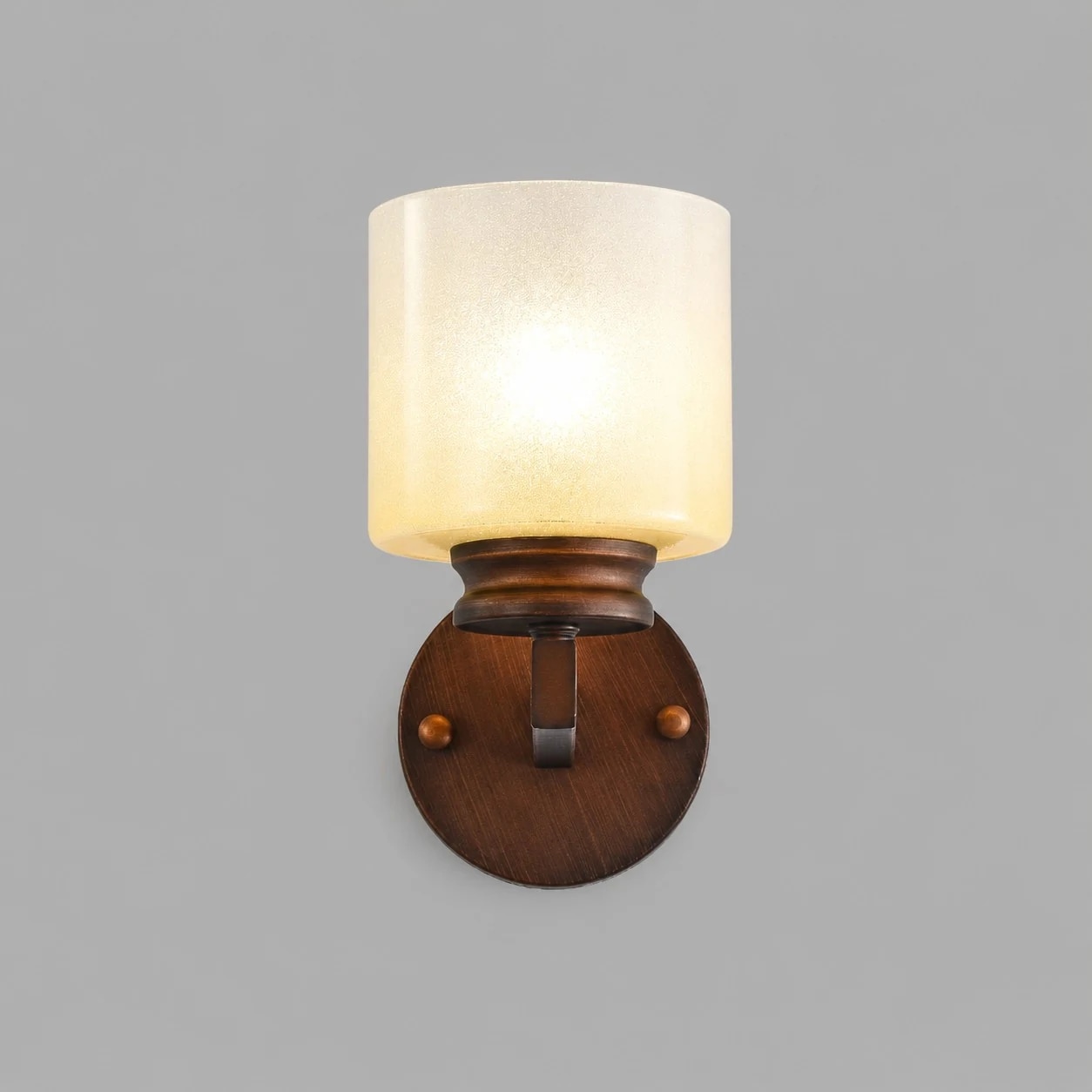 Front view of the lit aged bronze wall sconce