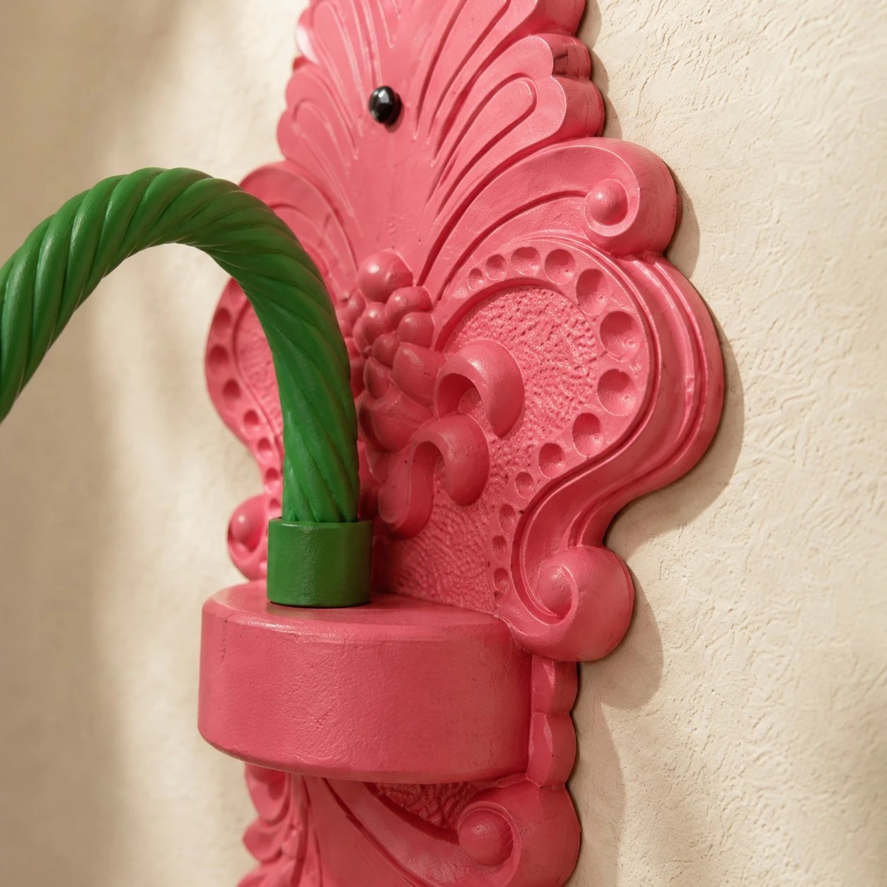 Detailweergave van de gebeeldhouwde achterplaat en de gebogen groene arm.
