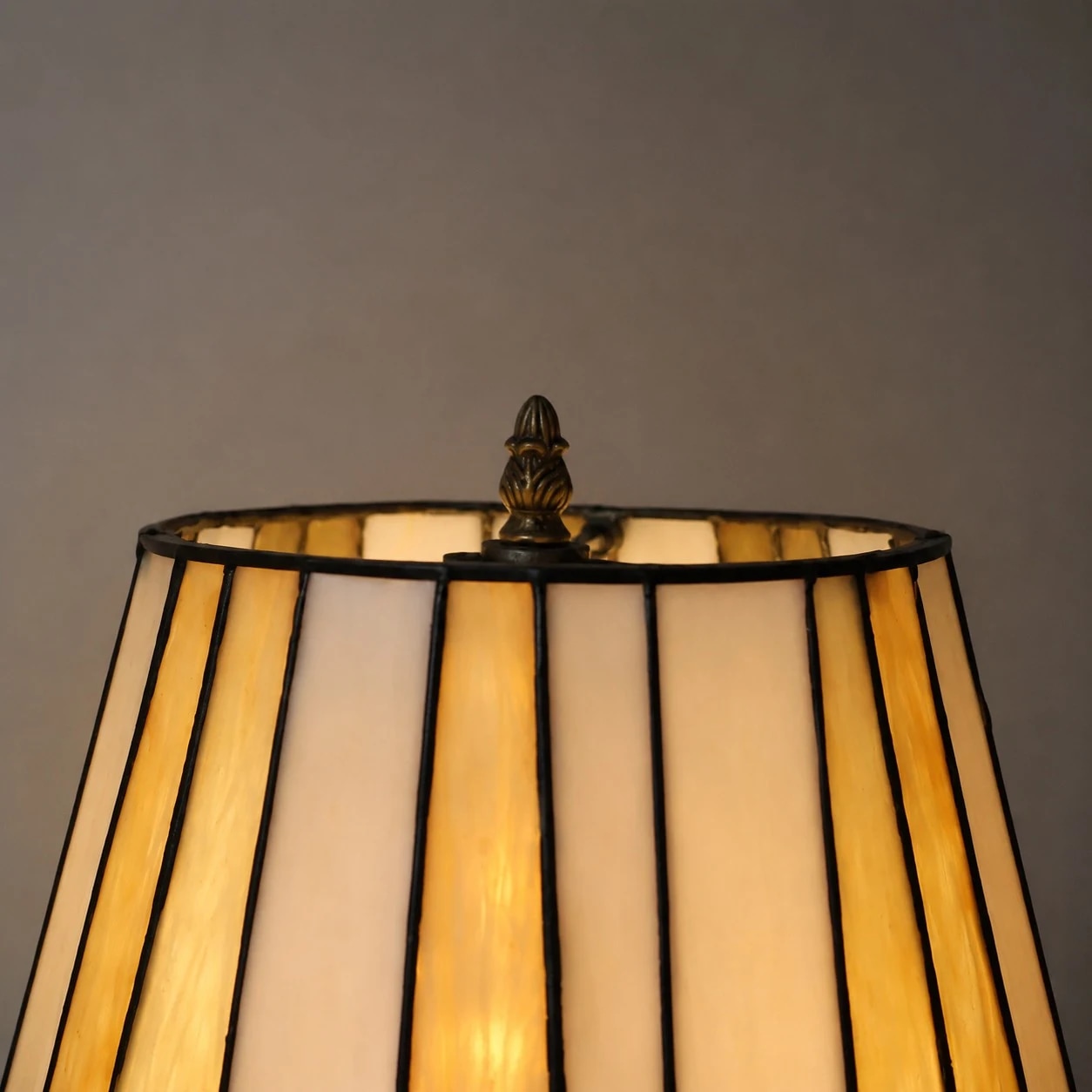 Primer plano de una pantalla de lámpara de vidrieras iluminada.