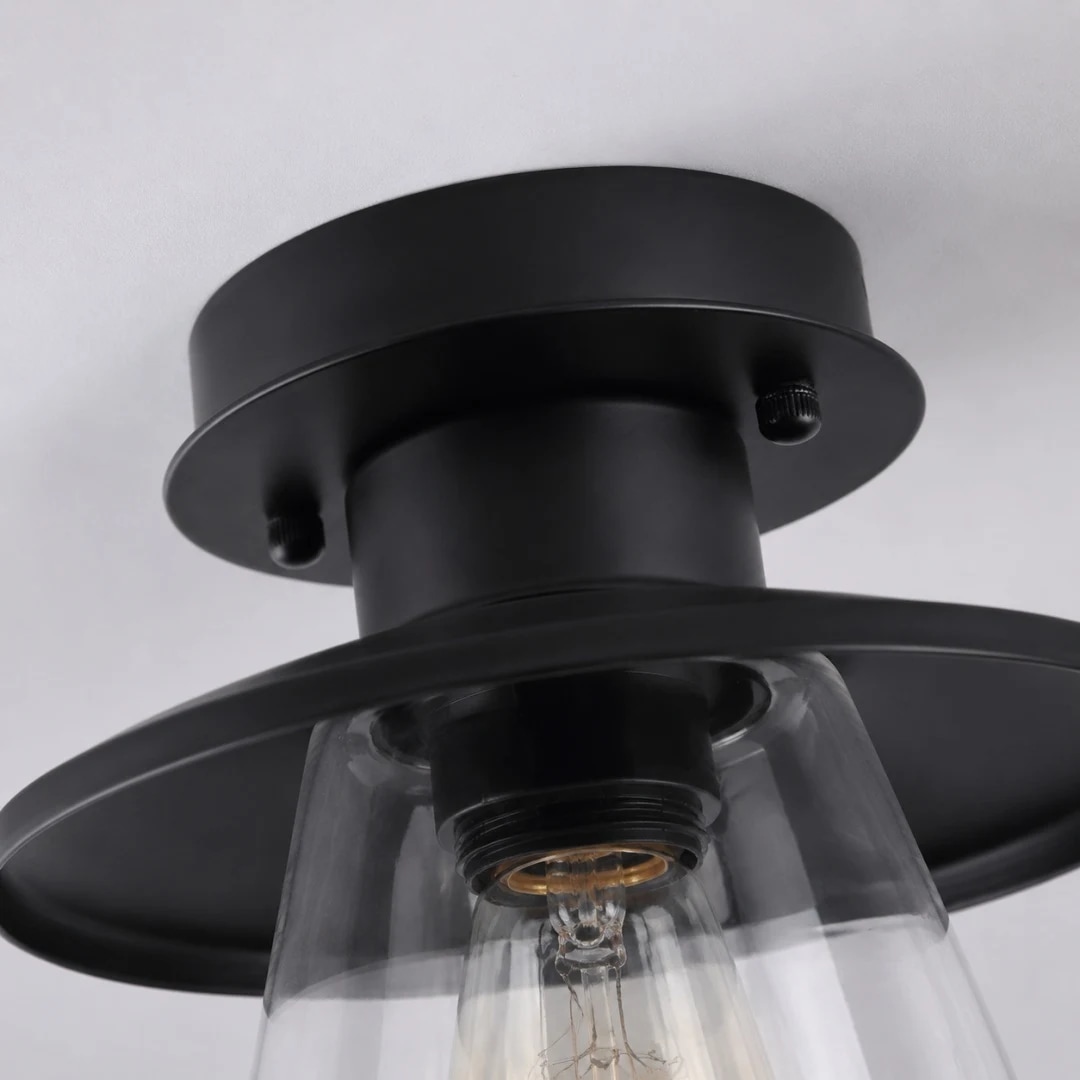 Détails du plafond en métal noir et de l'abat-jour en verre transparent