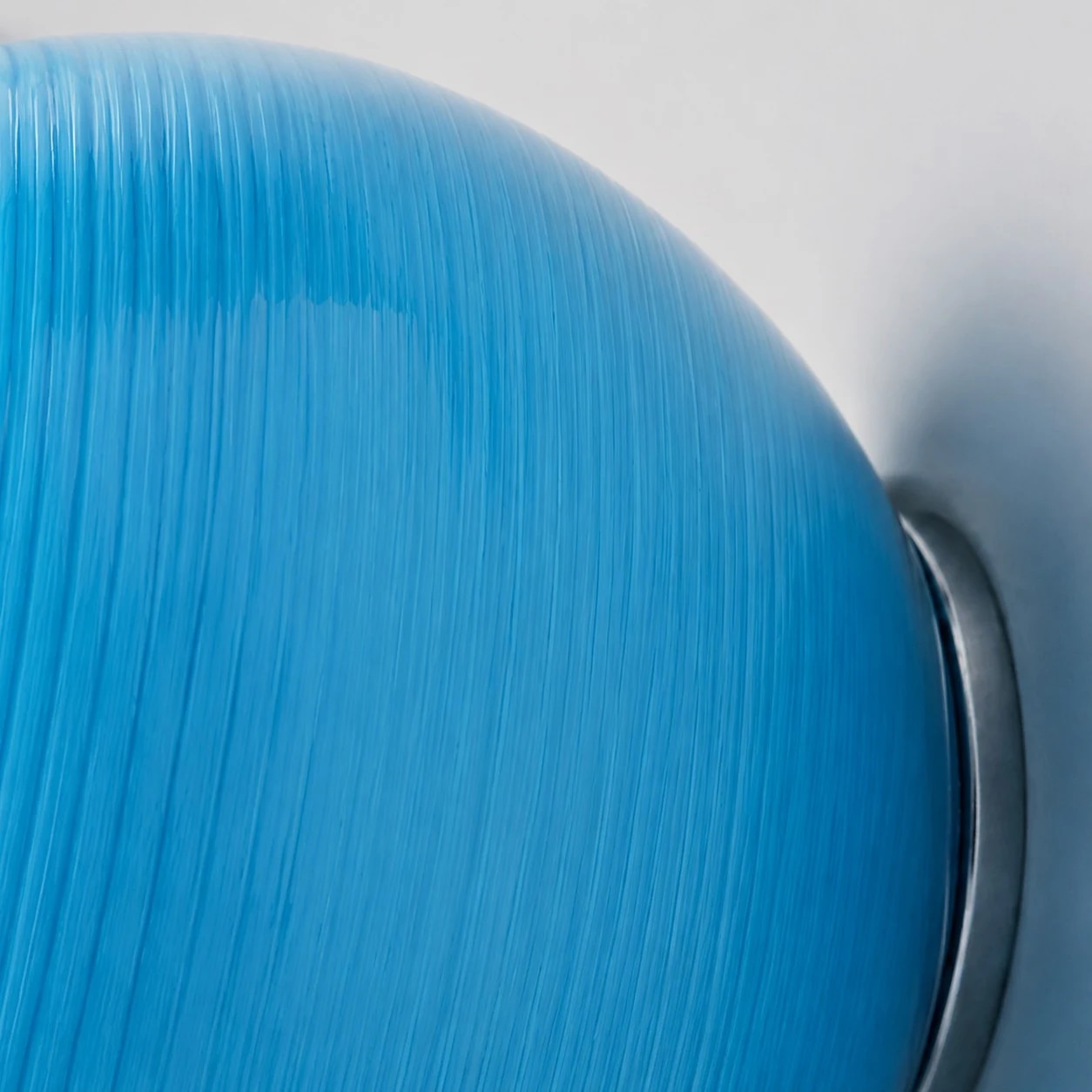 Detalle del borde de cristal azul y del soporte de pared
