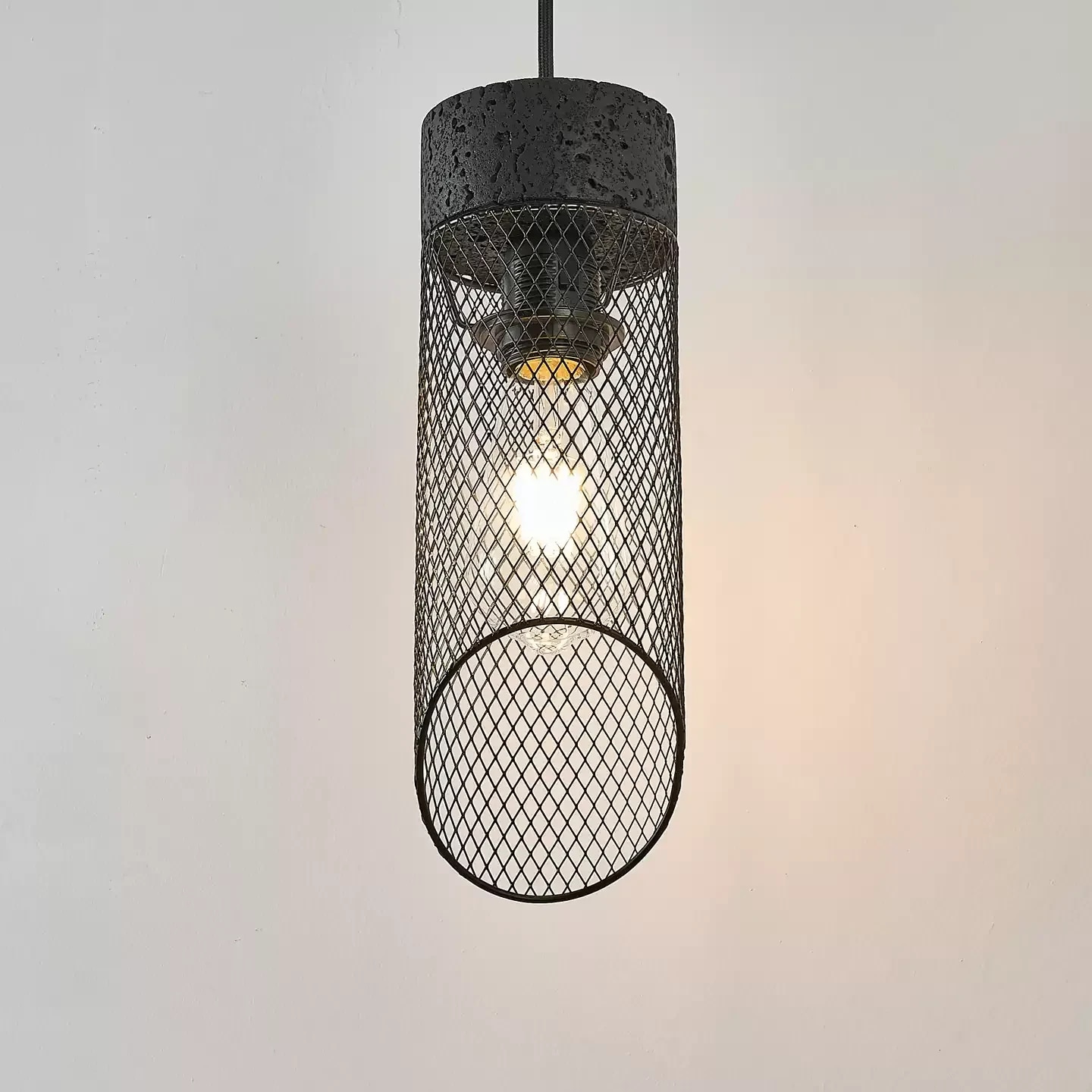 Black mesh shade glowing with bulb inside