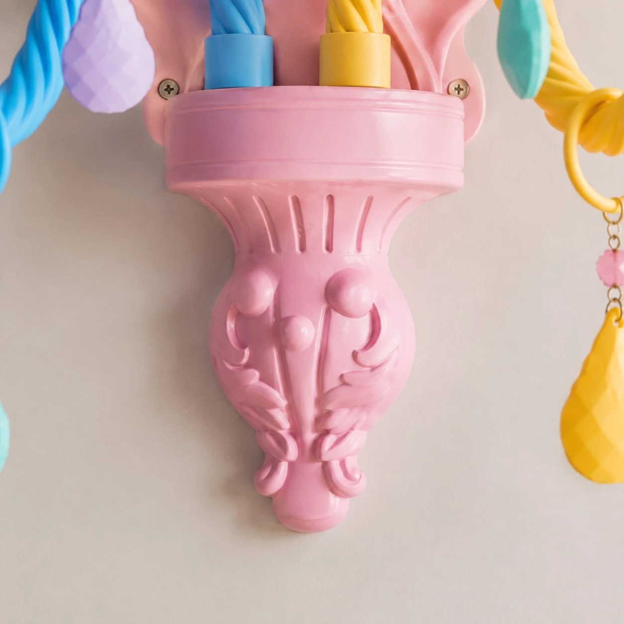 Detailweergave van de onderste, gebeeldhouwde voet van de wandlamp.