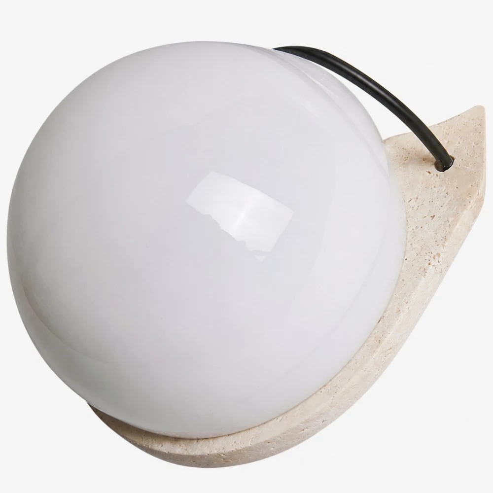 Detalhe aproximado de pedra travertino e globo de vidro branco