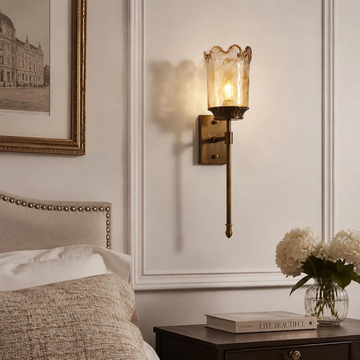 Brass amber glass wall sconce installed beside a bed