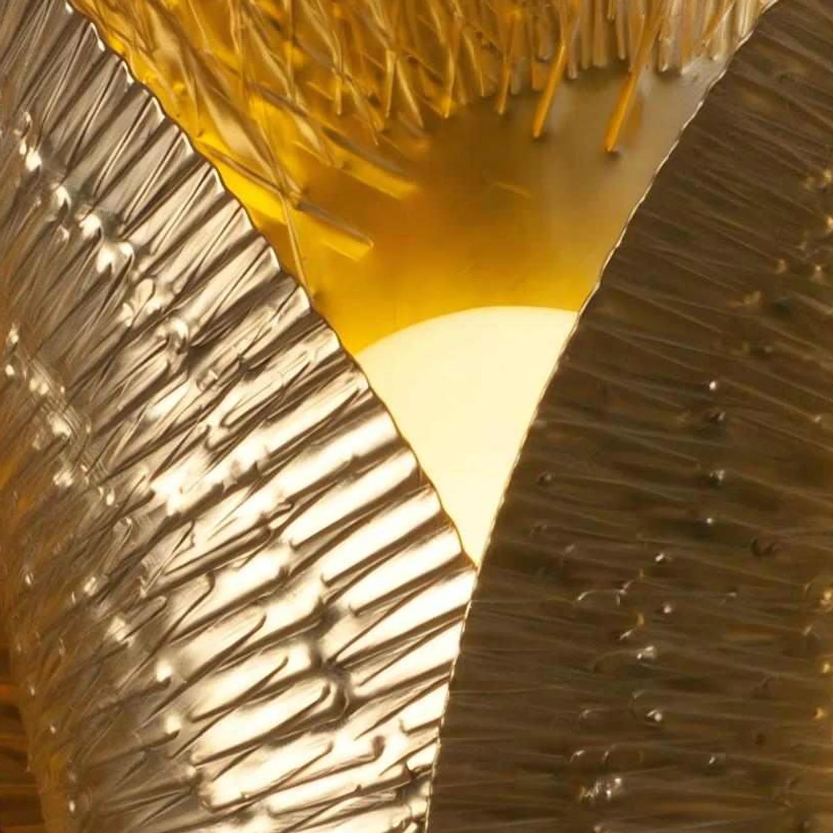 Close-up of lit overlapping brass shade edge