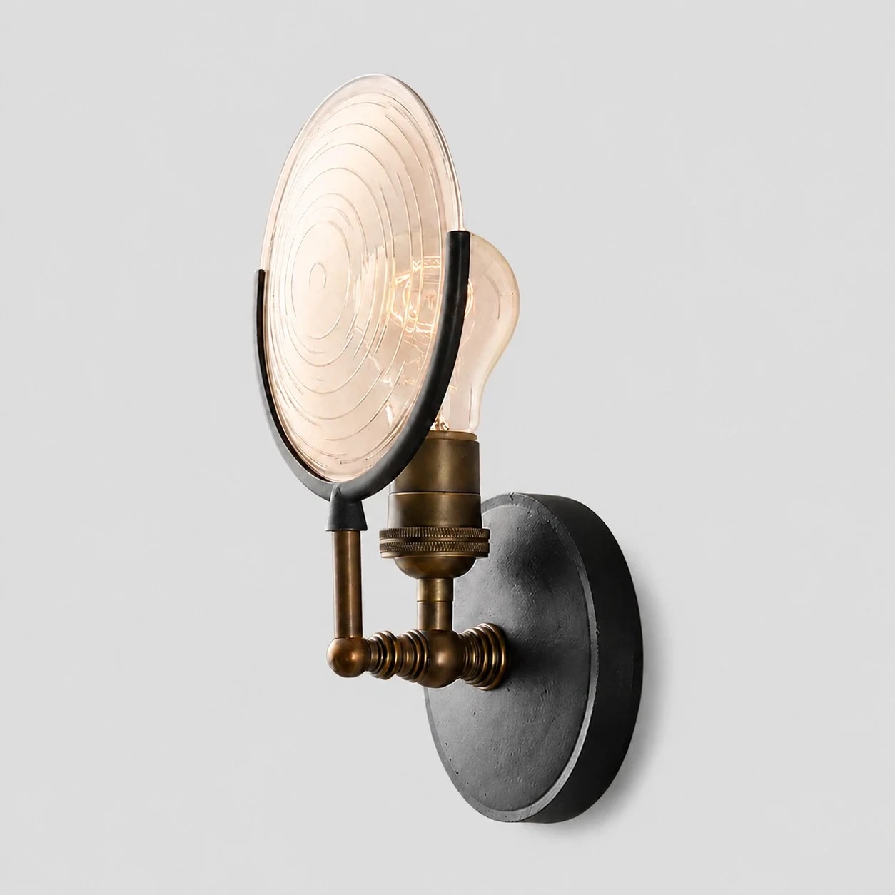 Angled detail view of the glass disc, bulb holder, and backplate