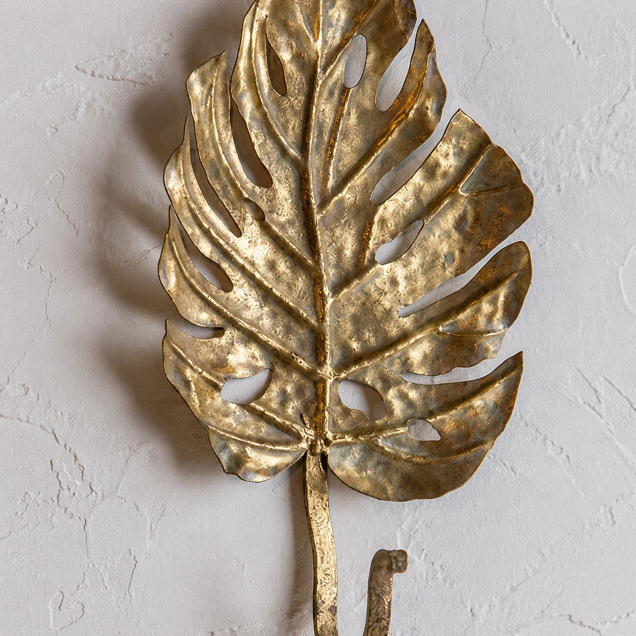 Antique-gold leaf wall hook showing raised botanical form