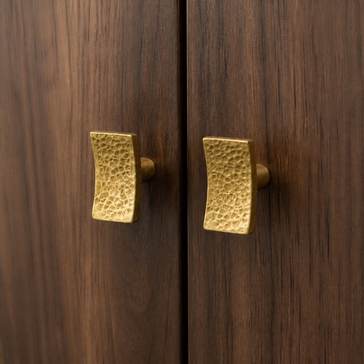 Pomos de latón martillado para armarios instalados en puertas de madera oscura