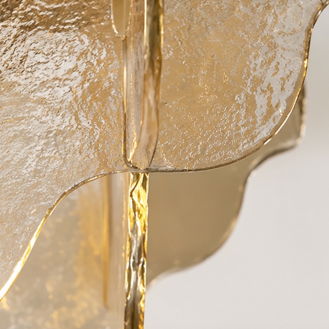 Närbild av texturerat bärnstensfärgat glas och metallstång