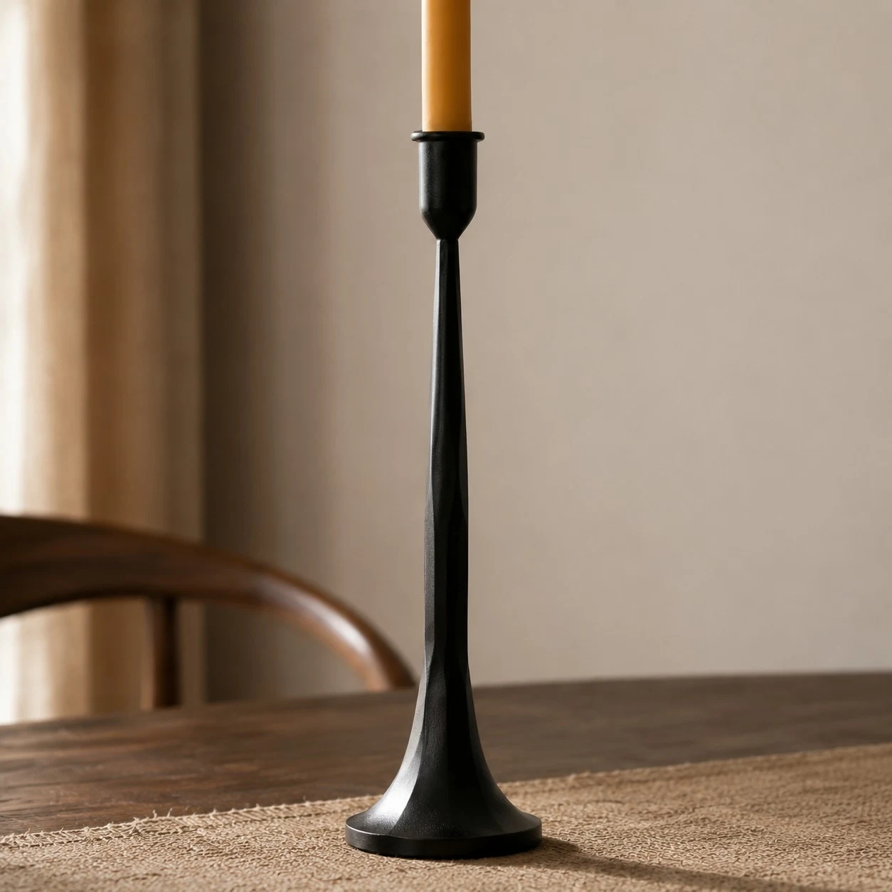 Hög svart ljusstake i järn med utsvängd bas