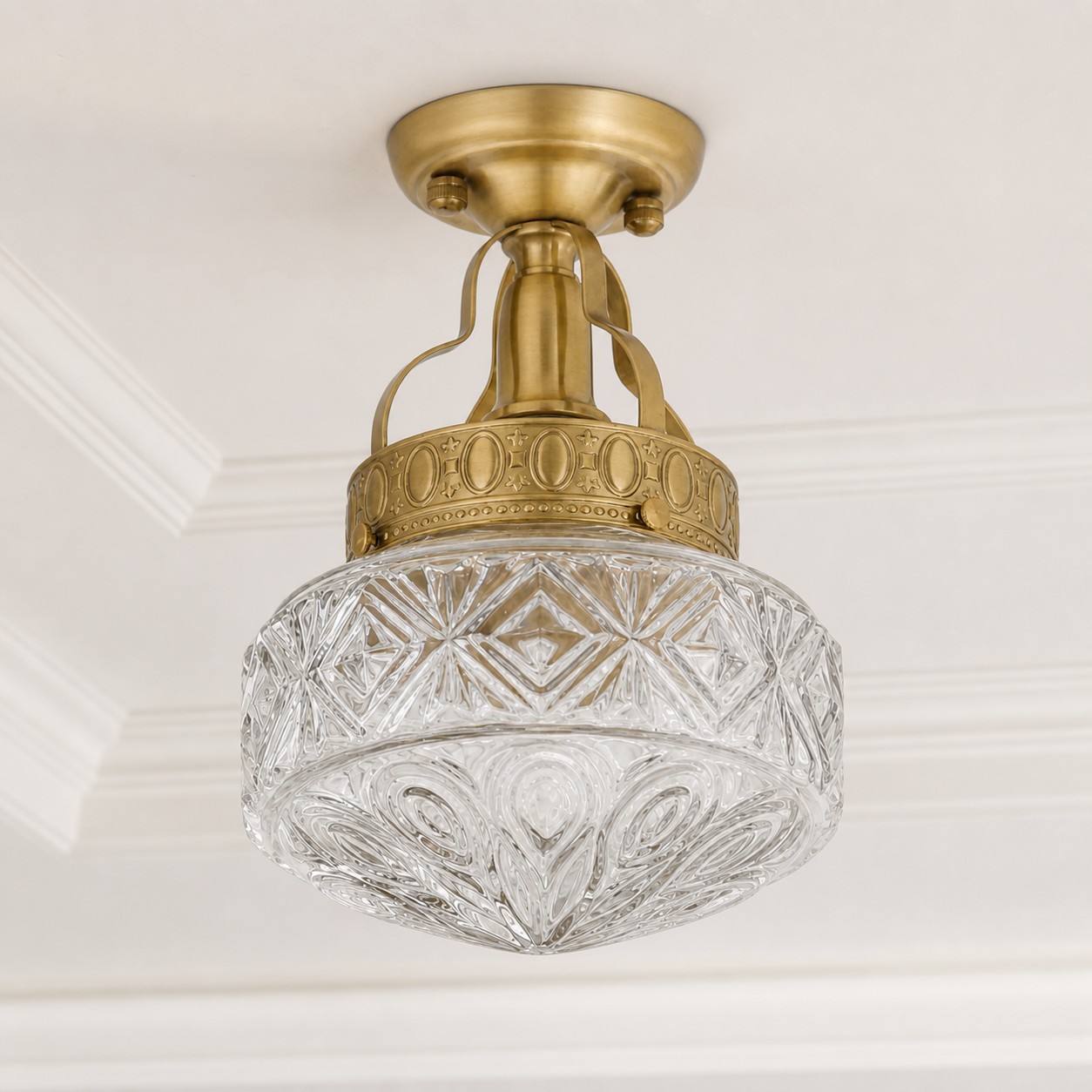 Klarglaspräglad art déco-taklampa i ljus klassisk interiör