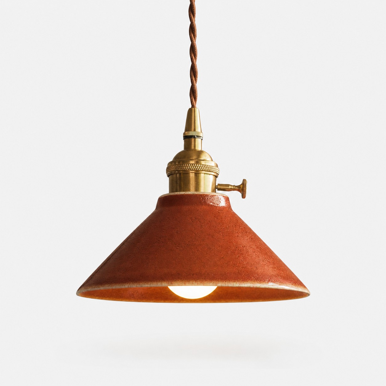 Russet red glazed ceramic pendant light with antique brass-finished hardware