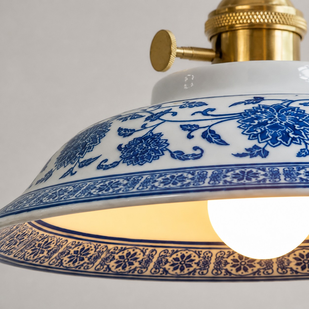 Close-up of the ceramic shade floral border and warm bulb glow