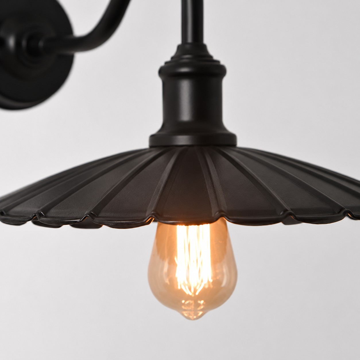Vägglampa i antik brons med skärm och armdetaljer