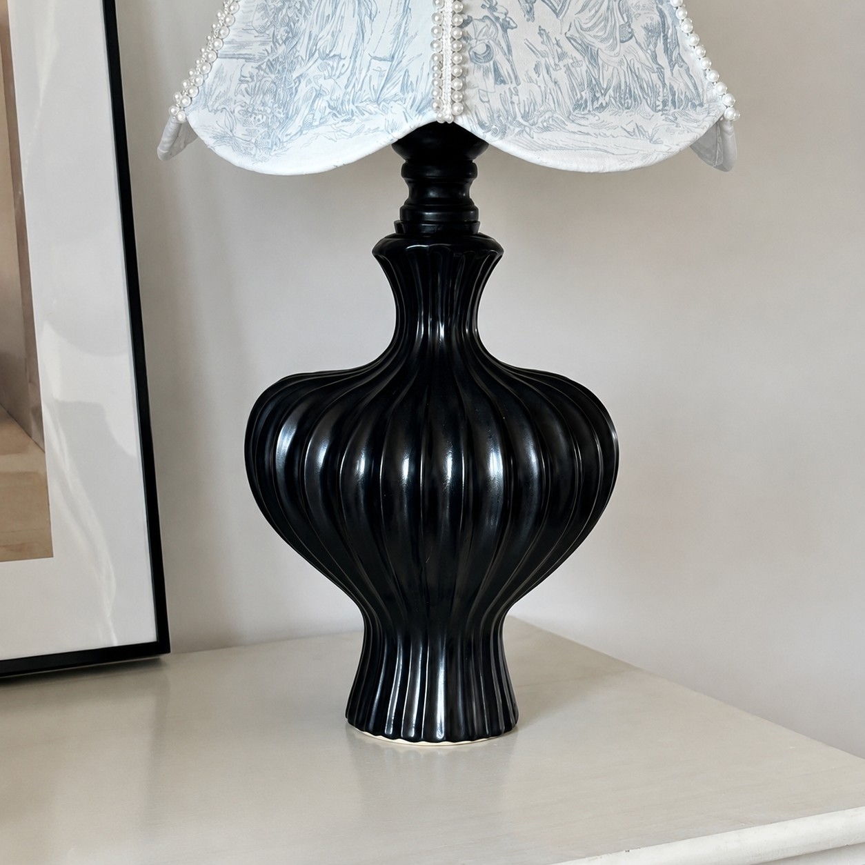 Svart skulptural bordslampfotsdetalj
