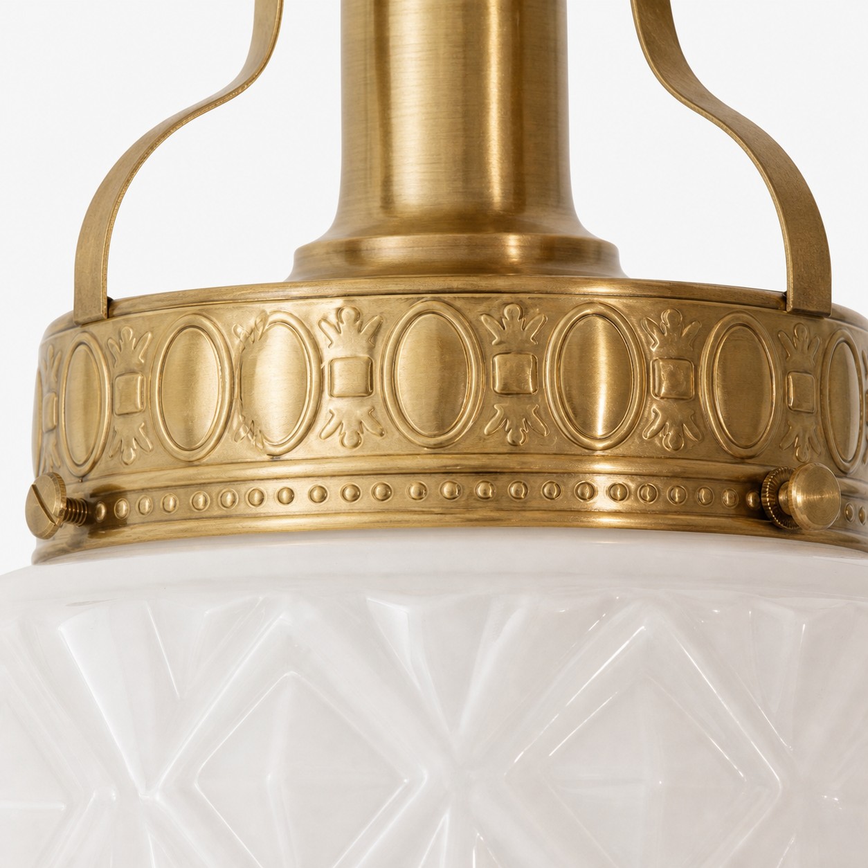 Detalj av präglad mässingsram på präglad glastaklampa