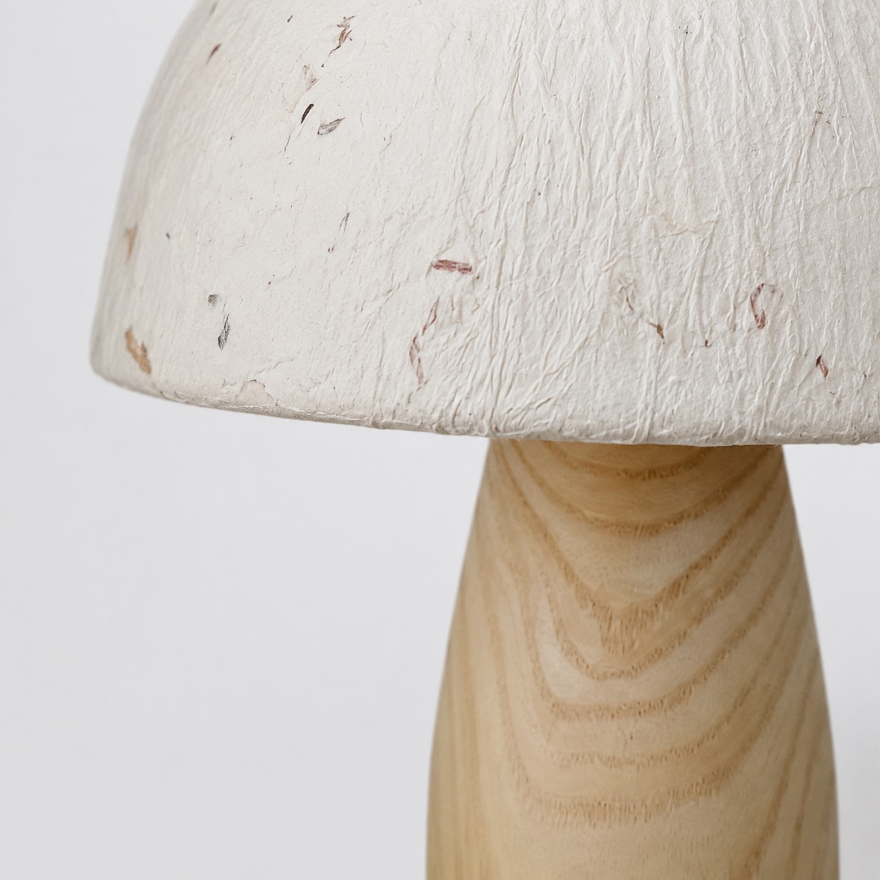 Pantalla de papel y base de madera natural en primer plano.