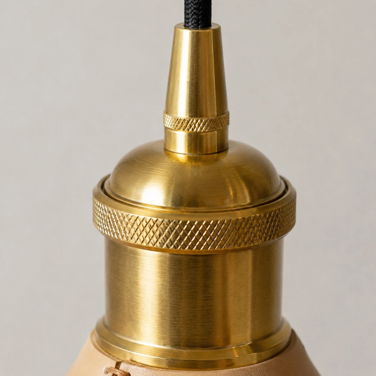 Brass tone cap and cord detail on cone pendant