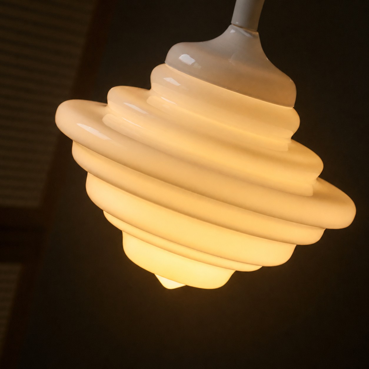 Verlichte witte glazen hanglamp, close-up.