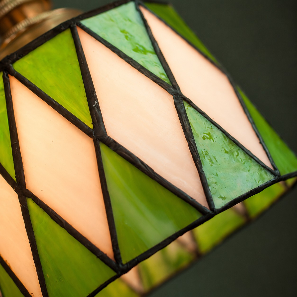 Green stained-glass pendant styled in a room